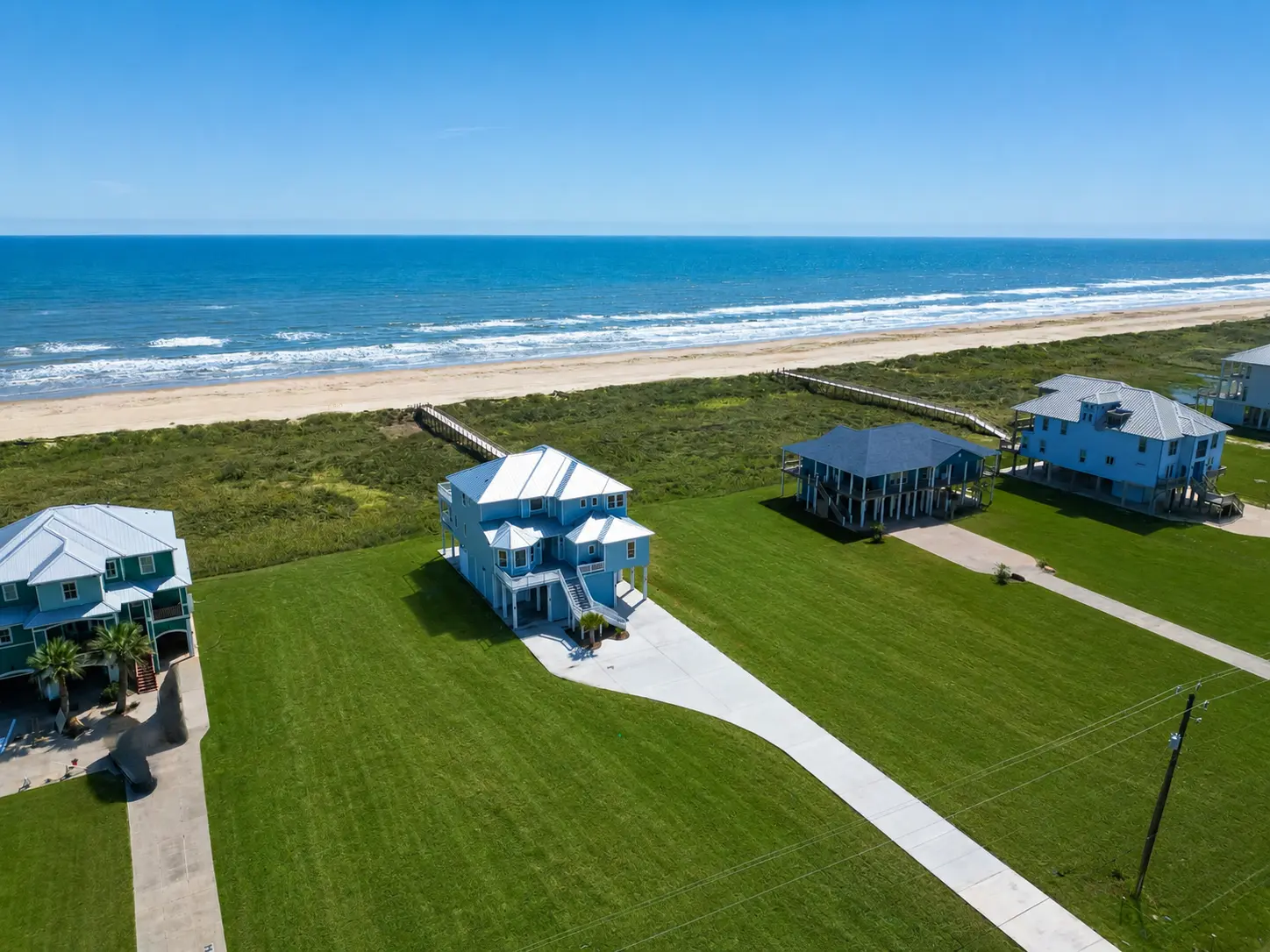A beachfront address with the Gulf and neighborhood walkover just beyond the home.